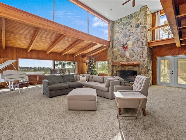 carpeted living room with a fireplace, a healthy amount of sunlight, and wooden walls