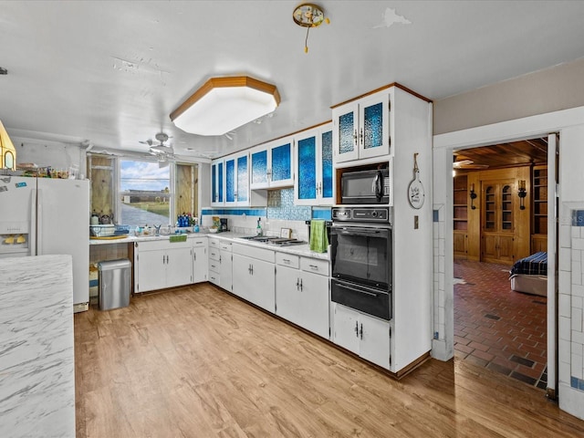 kitchen with decorative backsplash, white cabinetry, ceiling fan, and black appliances