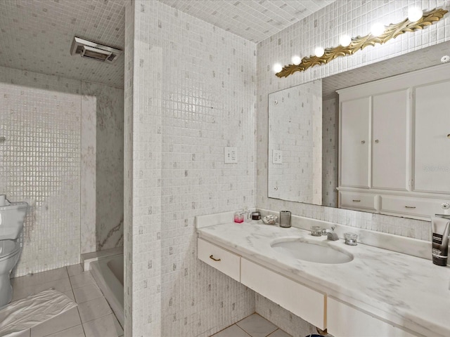 bathroom featuring toilet, tile patterned floors, a washtub, and sink