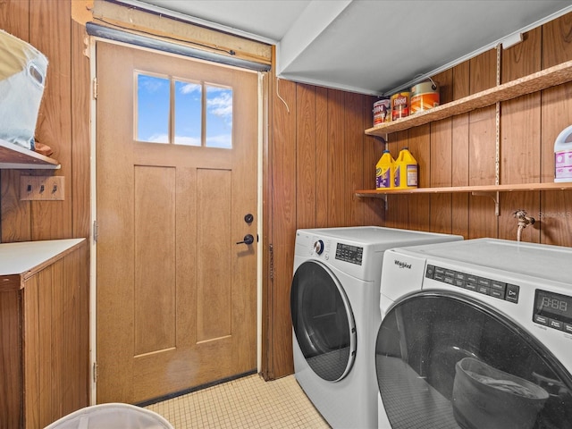 washroom featuring light tile patterned floors, separate washer and dryer, and wooden walls