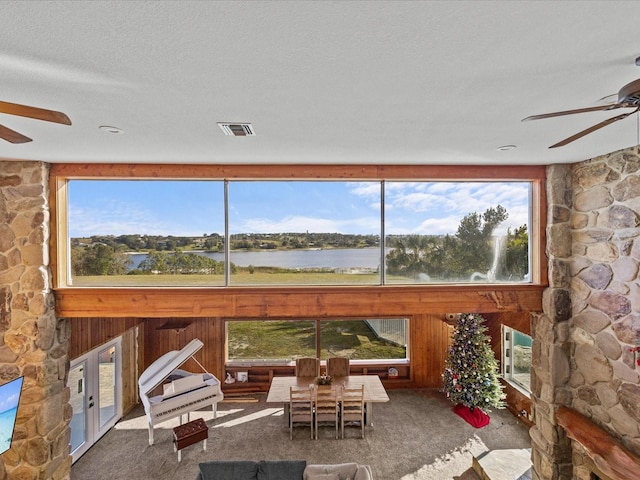 sunroom / solarium featuring a water view and ceiling fan