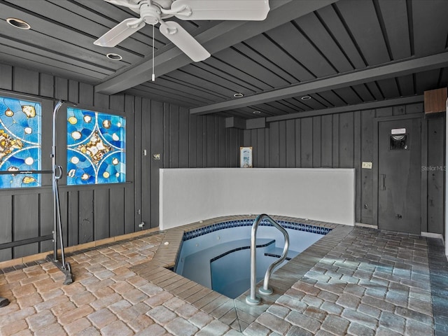 view of swimming pool with ceiling fan and an indoor hot tub