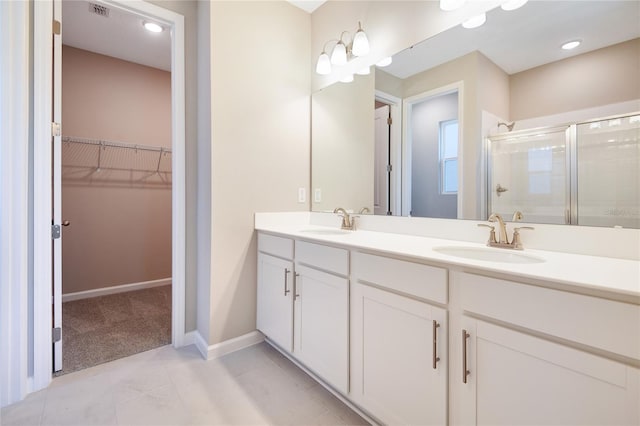 bathroom featuring tile patterned flooring, vanity, and a shower with door