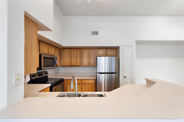 kitchen featuring sink, kitchen peninsula, stainless steel appliances, and a high ceiling