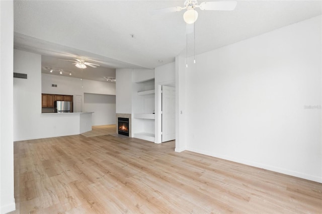 unfurnished living room featuring ceiling fan, light hardwood / wood-style floors, and a multi sided fireplace