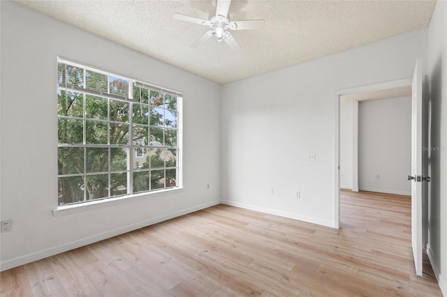 spare room featuring a textured ceiling, light wood-type flooring, and ceiling fan