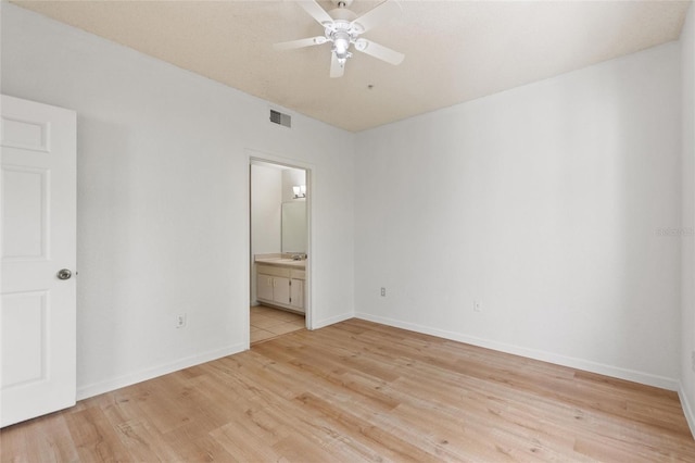 unfurnished bedroom with light wood-type flooring, ensuite bathroom, and ceiling fan