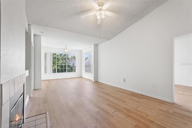 unfurnished living room featuring ceiling fan, light hardwood / wood-style floors, and a textured ceiling