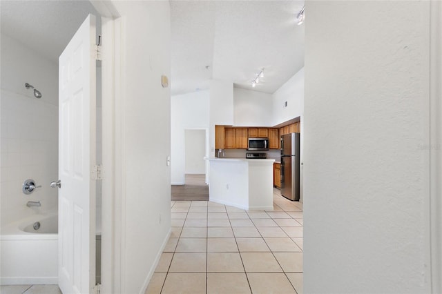 kitchen with rail lighting, light tile patterned floors, and stainless steel appliances