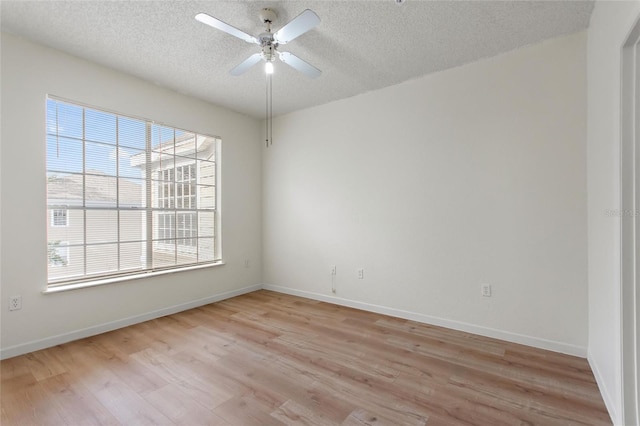 empty room featuring ceiling fan, light hardwood / wood-style floors, and a textured ceiling