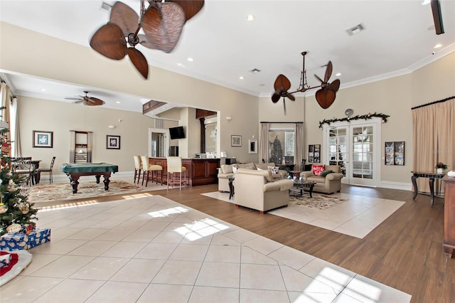 tiled living room featuring ceiling fan, ornamental molding, and pool table