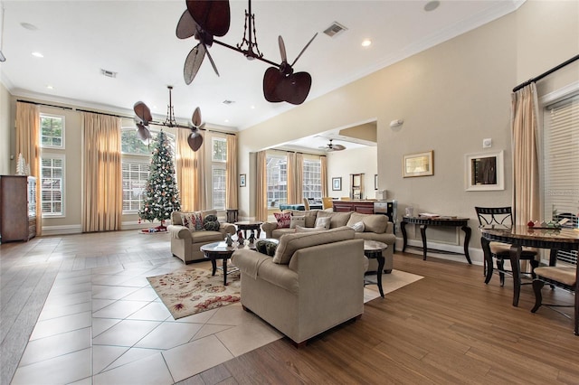 living room featuring ceiling fan with notable chandelier and crown molding