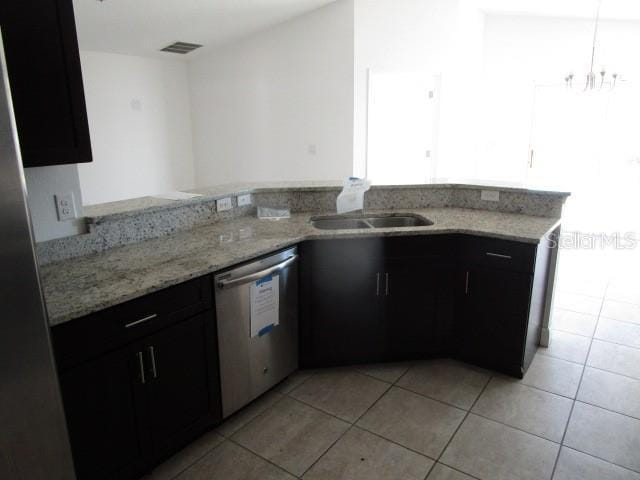 kitchen featuring an inviting chandelier, light stone counters, stainless steel dishwasher, kitchen peninsula, and light tile patterned floors