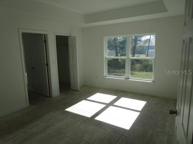 unfurnished bedroom featuring a tray ceiling