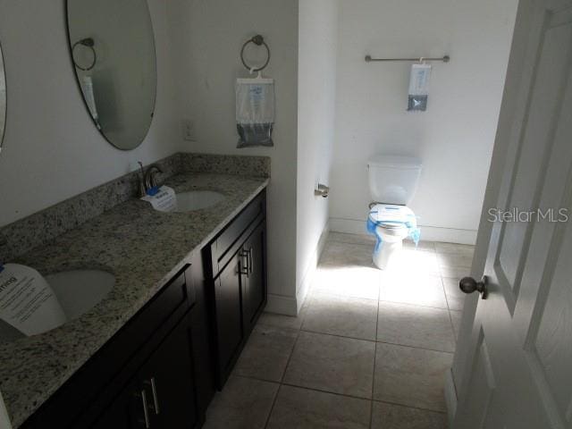 bathroom with tile patterned floors, vanity, and toilet