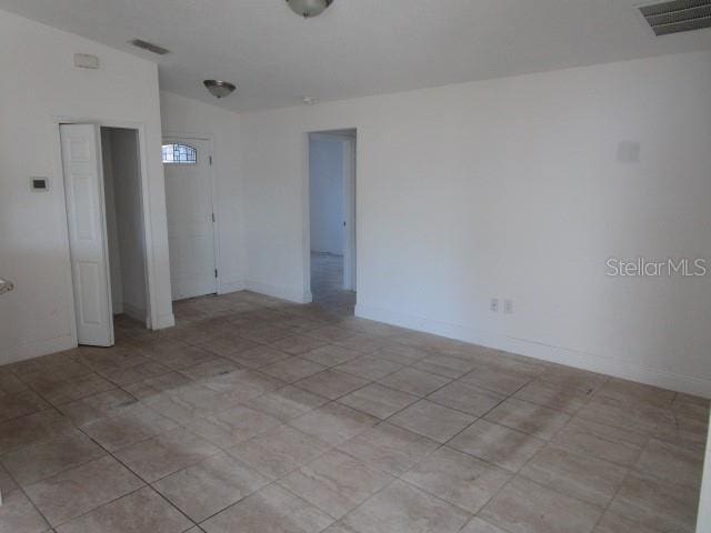 spare room featuring lofted ceiling