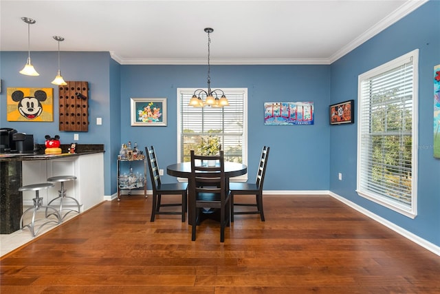 dining space with ornamental molding, dark hardwood / wood-style floors, and an inviting chandelier