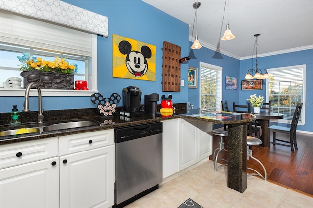 kitchen featuring pendant lighting, sink, stainless steel dishwasher, light tile patterned floors, and white cabinetry