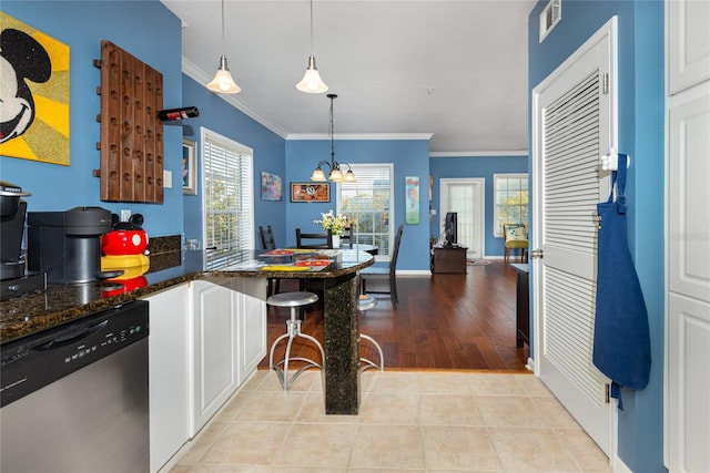 kitchen with decorative light fixtures, stainless steel dishwasher, ornamental molding, and light tile patterned flooring