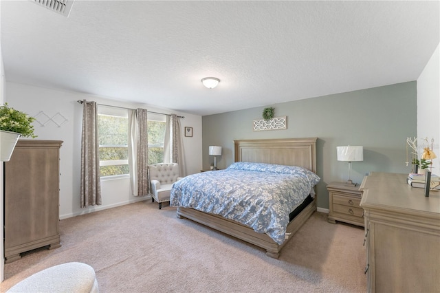 bedroom featuring light carpet and a textured ceiling