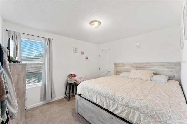 bedroom featuring light carpet and a textured ceiling