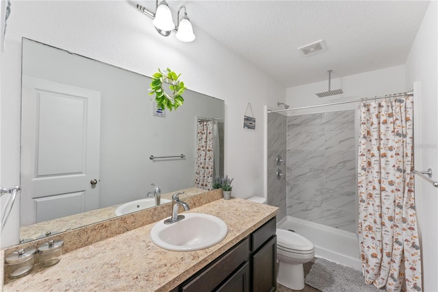 bathroom featuring curtained shower, vanity, a textured ceiling, and toilet