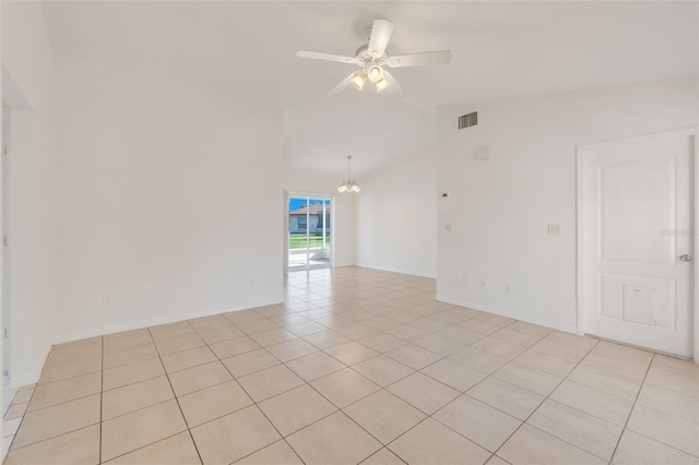 tiled spare room featuring lofted ceiling and ceiling fan with notable chandelier