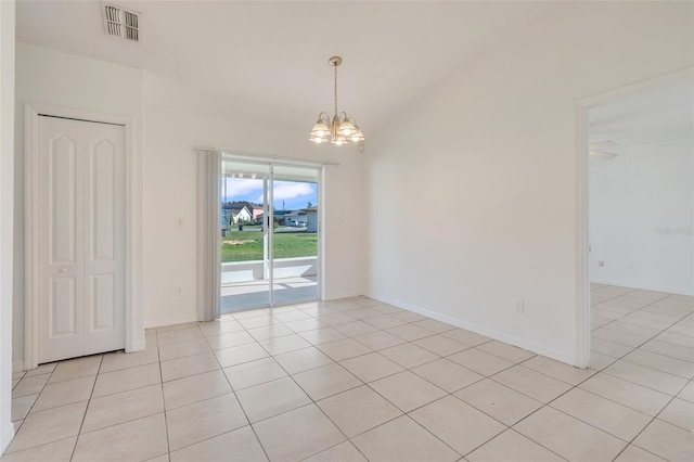 tiled empty room with an inviting chandelier