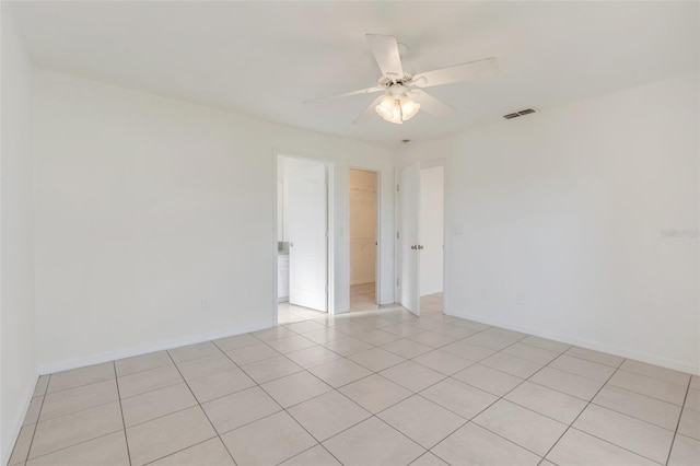 tiled spare room with ceiling fan