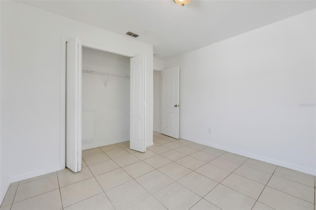 unfurnished bedroom featuring light tile patterned floors and a closet