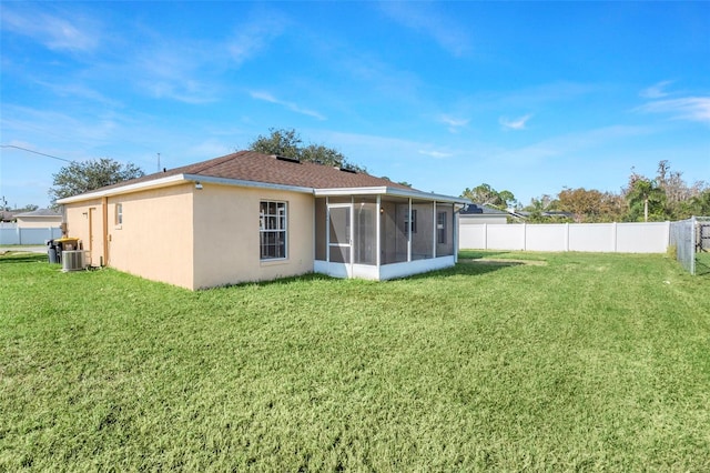 back of property featuring a sunroom, central AC unit, and a yard