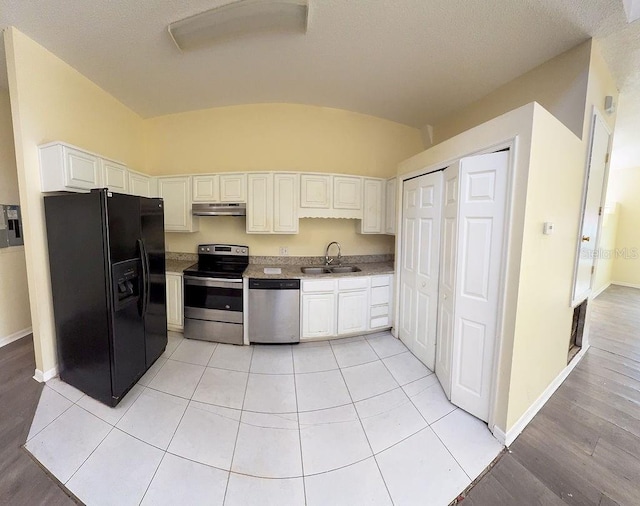 kitchen with white cabinetry, appliances with stainless steel finishes, light tile patterned flooring, and sink