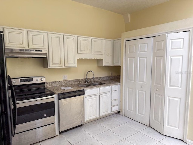 kitchen with white cabinets, appliances with stainless steel finishes, sink, and light tile patterned floors