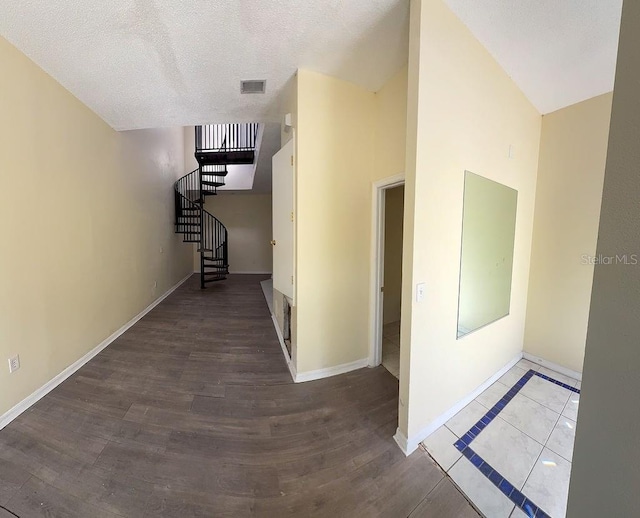 corridor with hardwood / wood-style flooring and a textured ceiling