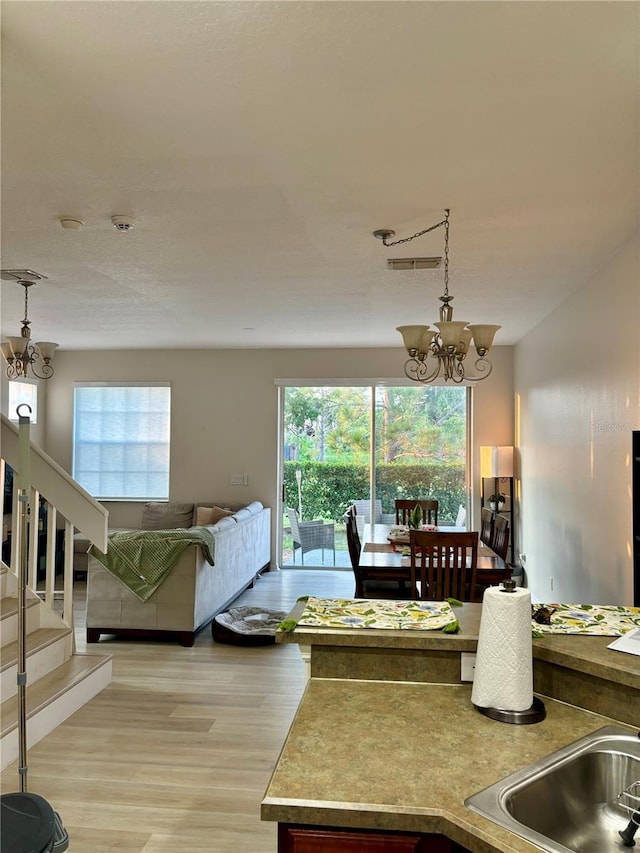 living room featuring light hardwood / wood-style floors and a notable chandelier