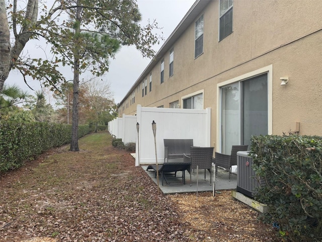 view of side of home featuring central air condition unit and a patio