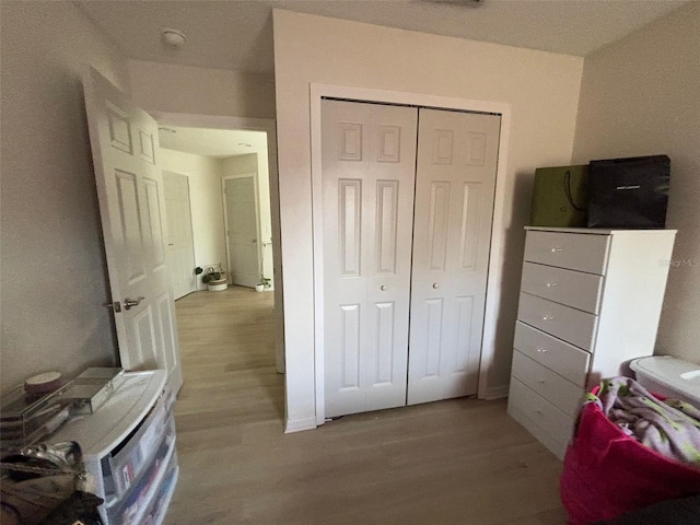 bedroom with light wood-type flooring and a closet