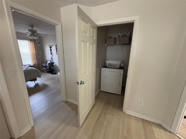 laundry room with ceiling fan, washer / dryer, and light wood-type flooring