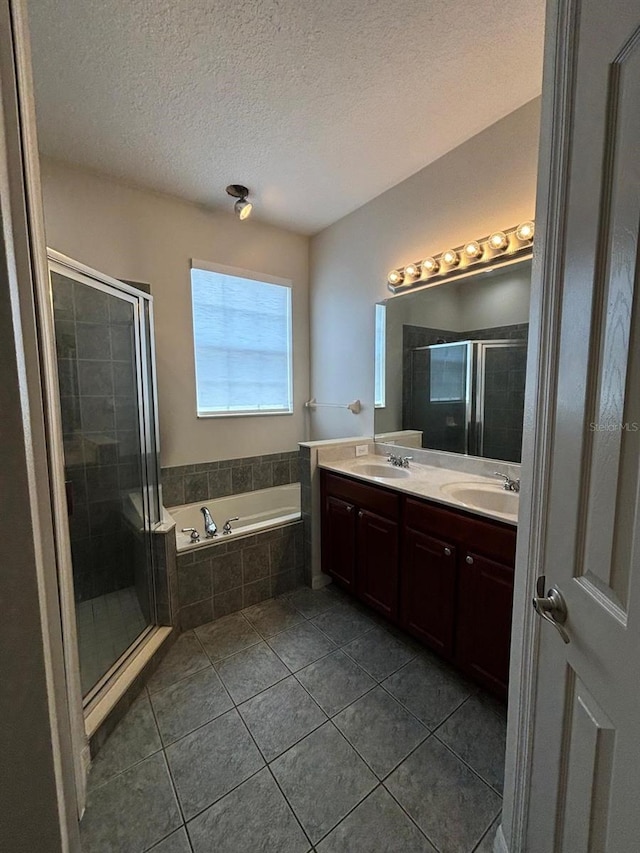 bathroom featuring tile patterned flooring, vanity, a textured ceiling, and shower with separate bathtub