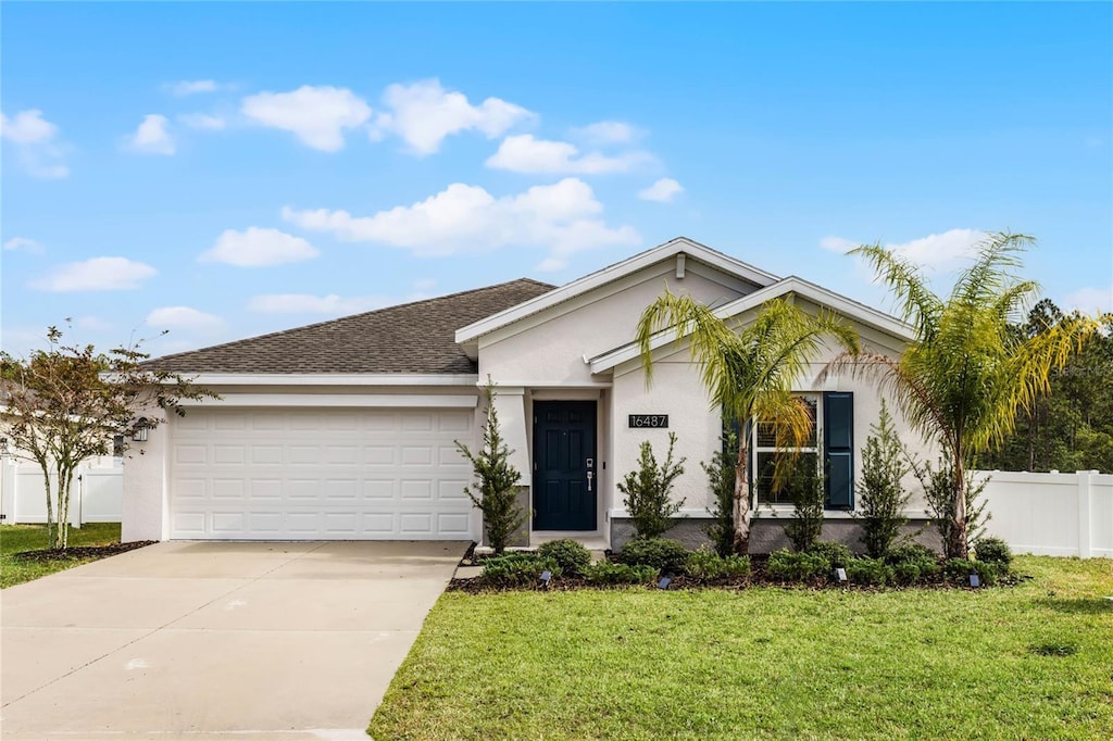 ranch-style home featuring a front lawn and a garage