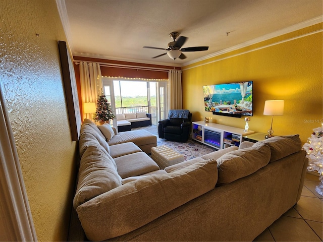 living room with light tile patterned floors, ceiling fan, and ornamental molding