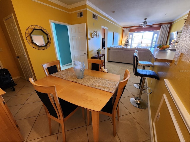 dining space featuring ceiling fan, crown molding, and light tile patterned flooring