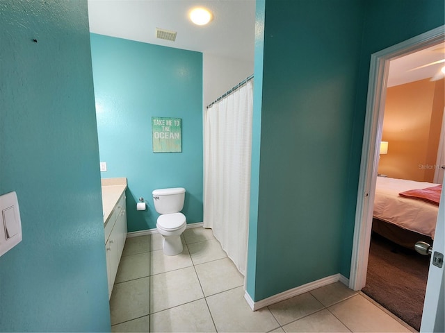 bathroom with toilet, vanity, and tile patterned floors