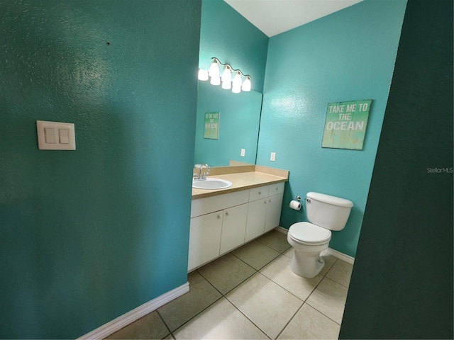 bathroom with tile patterned flooring, vanity, and toilet