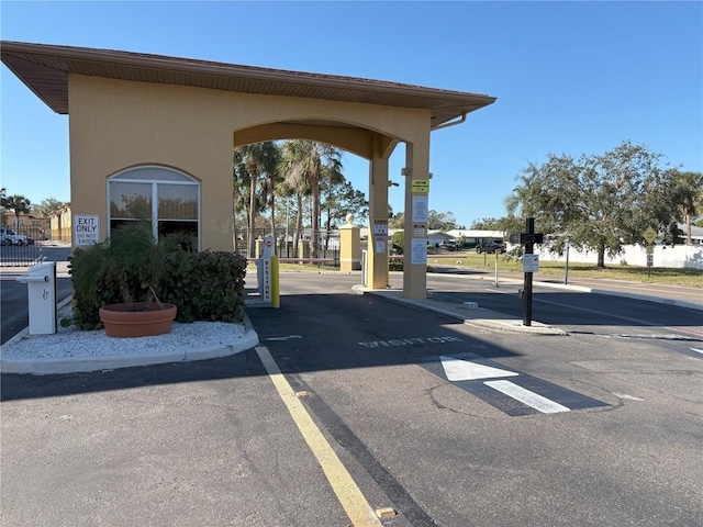 view of road with curbs and a gate