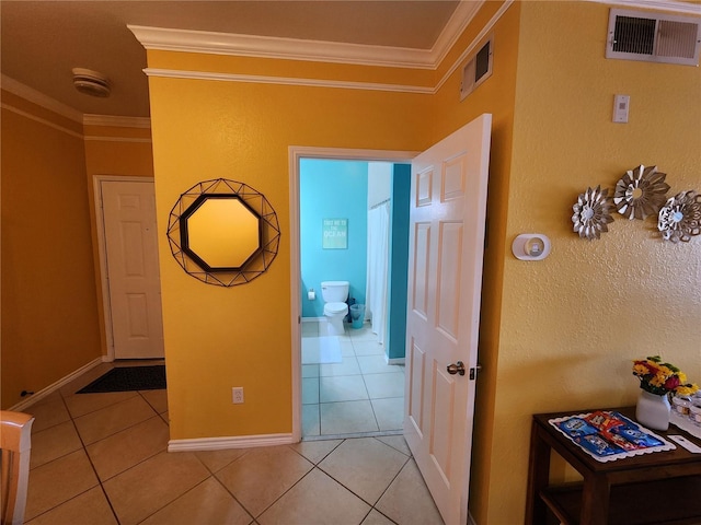 hall featuring light tile patterned flooring, visible vents, and ornamental molding