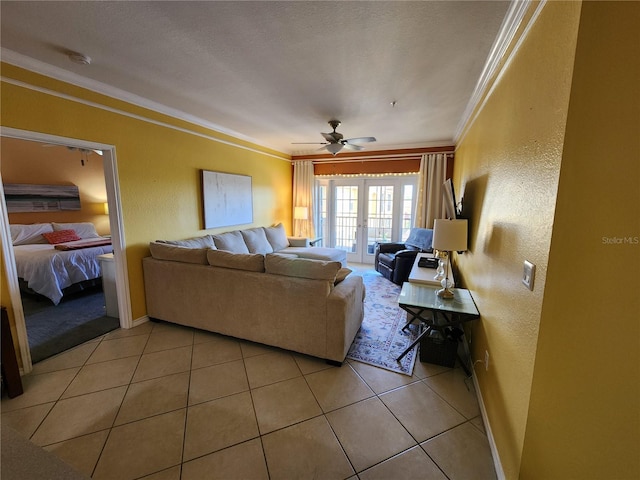 living area featuring a ceiling fan, crown molding, light tile patterned flooring, and a textured wall