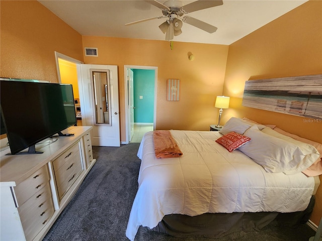 bedroom with dark colored carpet, visible vents, baseboards, and ceiling fan