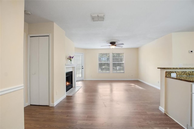 unfurnished living room with wood-type flooring and ceiling fan