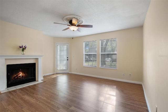 unfurnished living room featuring a textured ceiling, light hardwood / wood-style floors, and ceiling fan